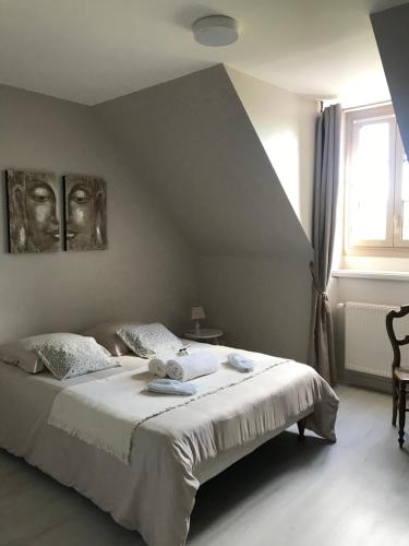 Saint-Sulpice-le-DunoisAuberge de la fontaine aux loups的一间卧室配有一张带白色床单的床和一扇窗户。