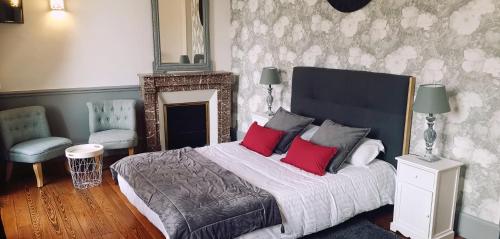 波旁朗西Logis Hotel La Tourelle du Beffroi的一间卧室配有一张大床和两个红色枕头