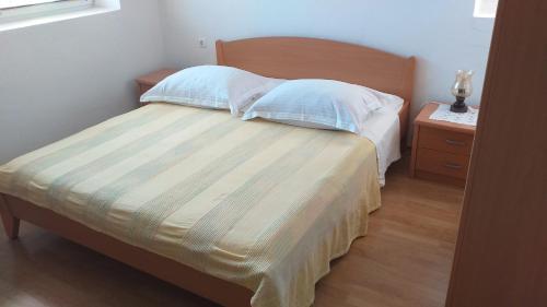 拉斯托伏Lastovo City Center的一间卧室配有带两个枕头的床和床头柜