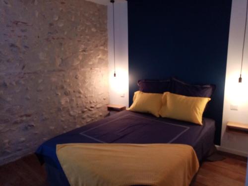 CanohèsAppartement classé 3 étoiles - Canohès的一间卧室配有一张带两盏灯的床。