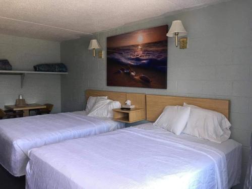 柏斯海滩High Seas Motel的配有白色床单的酒店客房内的两张床