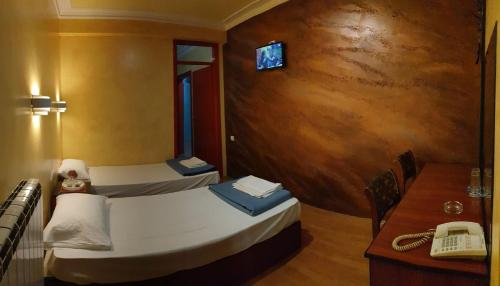 贝尔格莱德ESTRADA Lux的客房设有两张床、一张桌子和一部电话。