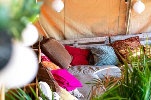 弗利兰Surfana Beach camping hostel Bed & Breakfast Vlieland的蒙古包沙发上的一组枕头
