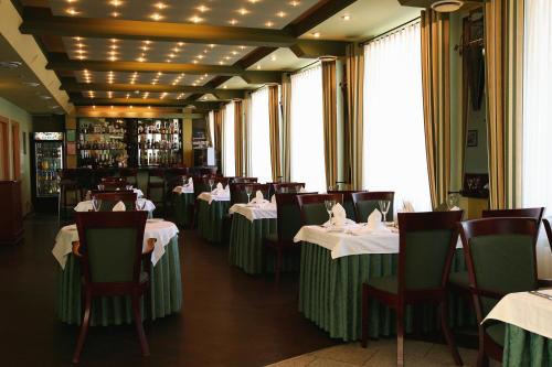 希奥利艾希奥利狩猎边缘酒店的餐厅配有桌椅和白色的桌布