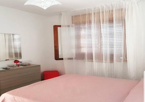 庞特卡格纳诺Vista Volo的卧室配有粉红色的床和窗户。