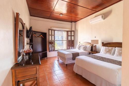 特拉科塔尔潘Hotel Doña Juana的酒店客房设有两张床和窗户。