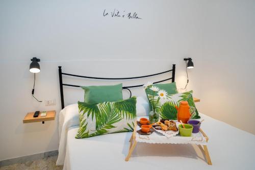 切塔拉La Zagara Holiday House - Cetara - Amalfi Coast的一张带绿色枕头的床和一张食物托盘
