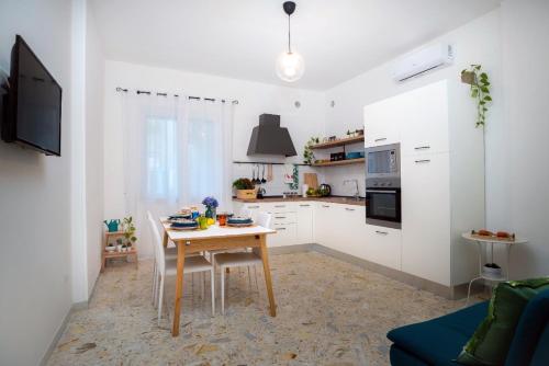 切塔拉La Zagara Holiday House - Cetara - Amalfi Coast的一间带木桌的厨房和一间带白色橱柜的厨房