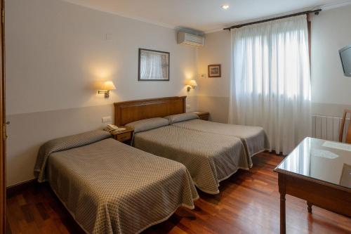 圣塞瓦斯蒂安乐库埃德酒店的酒店客房设有两张床和窗户。