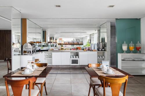 卡鲁阿鲁Citi Hotel Express Caruaru的一间带桌椅的用餐室和一间厨房