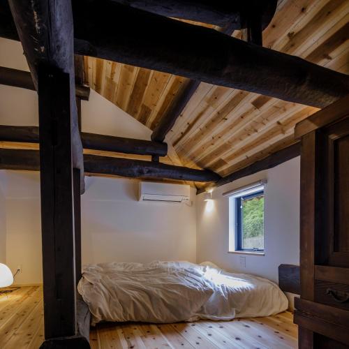 淡路kotobukian 寿庵的阁楼卧室配有1张床,铺有木地板。