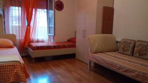 米兰Cara Revello的客房设有两张床、一张沙发和一个窗口。