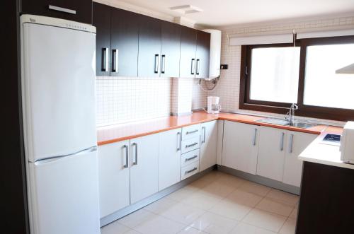 科蒂略科蒂略海景公寓的厨房配有白色橱柜和白色冰箱。