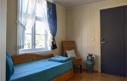 曼达尔Beautiful Apartment In Mandal With Kitchen的一间卧室设有一张床、一个窗口和一把椅子