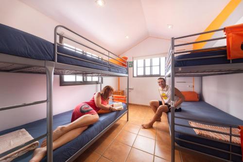 阿德耶拉托尔旅馆的两人坐在宿舍的双层床上