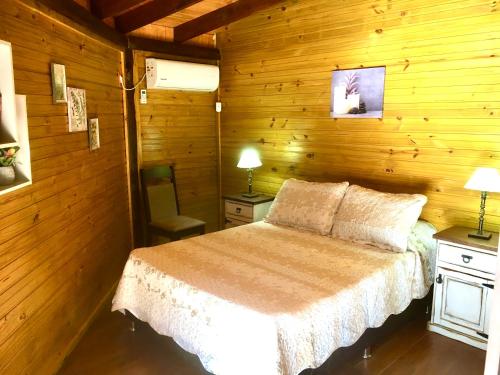 马尔多纳多Los Quetzales的卧室配有木墙内的一张床