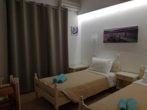 伊奥斯乔拉加利尼公寓式酒店的一间小卧室,配有两张床和窗帘