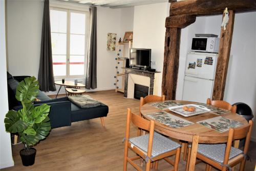 圣艾尼昂Gite Le Nid des Zoo Zio, 5mn Beauval, appartement terrasse centre-ville的厨房以及带桌椅的起居室。