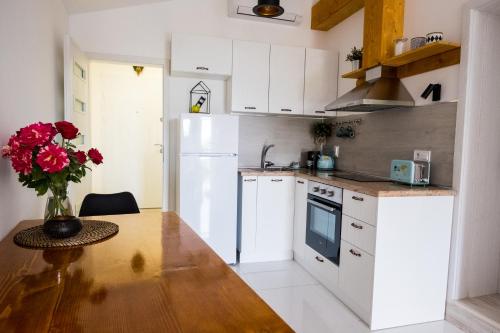 大特尔诺沃Tarno Guest House的厨房配有木桌和白色冰箱。