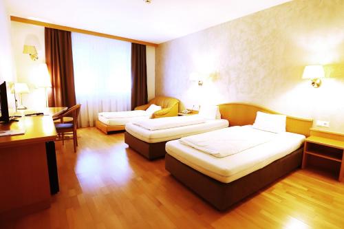 萍卡菲尔特平卡费尔德斯塔迪特酒店的酒店客房配有两张床和一张书桌