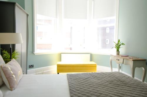 布莱顿霍夫Seaview Mansion Apartment - Central Hove with PARKING的卧室配有床、椅子和窗户。