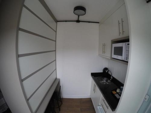 佩尼亚Vila Container的一间小厨房,配有白色的墙壁和微波炉