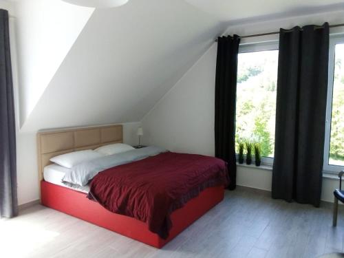 Brodnica DolnaWilla Brodnica的一间卧室设有红色的床和窗户。