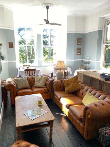 伊尔弗勒科姆The Devonian的客厅配有棕色皮沙发和桌子