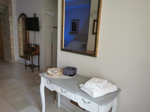 福贾B&B Casa Dilillo的桌子上方墙上的镜子,带毛巾