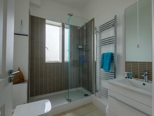 赖德Serene in Ryde的一间带玻璃淋浴和水槽的浴室