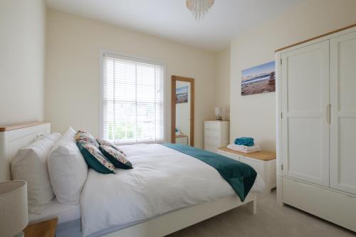 赖德Serene in Ryde的卧室配有带枕头的大型白色床
