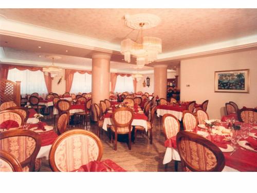 卡尔多纳佐埃尔伯格吉尔达酒店的一间带桌椅和吊灯的用餐室