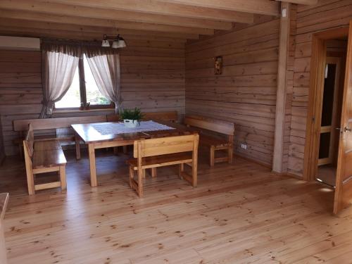 埃莱克特伦艾Abromiškių Sodyba的小屋内带桌椅的用餐室