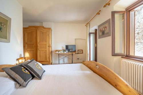 特伦托B&B S. Trinità 18 Suites & Rooms的一间卧室配有一张带木制床头板的床
