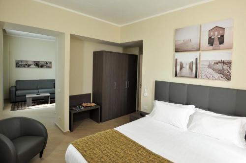 热那亚希艾曲西商务住宅酒店的配有一张床和一把椅子的酒店客房