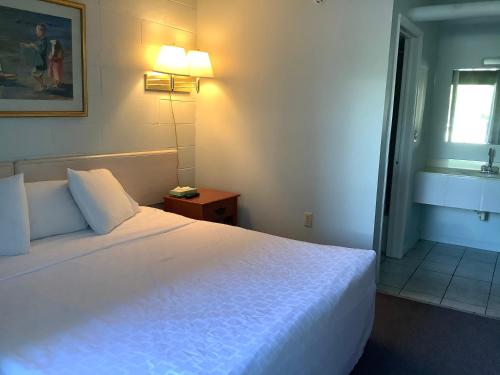 柏斯海滩High Seas Motel的酒店客房设有白色的床和窗户。