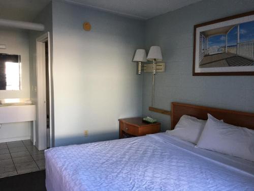 柏斯海滩High Seas Motel的卧室配有白色的床和窗户。