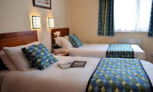 波特兰高地酒店的一间酒店客房,配有两张床和一本书