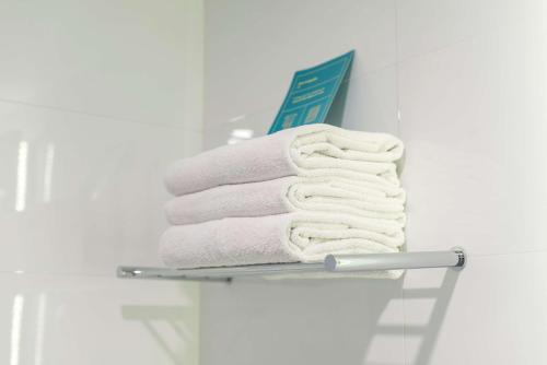 利马Libre Hotel, BW Signature Collection by Best Western的浴室毛巾架上的毛巾堆