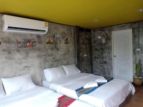 Prakhon Chaiเซราะกราว บูติก รีสอร์ท Sohground Boutique Resort的卧室设有两张黄色天花板