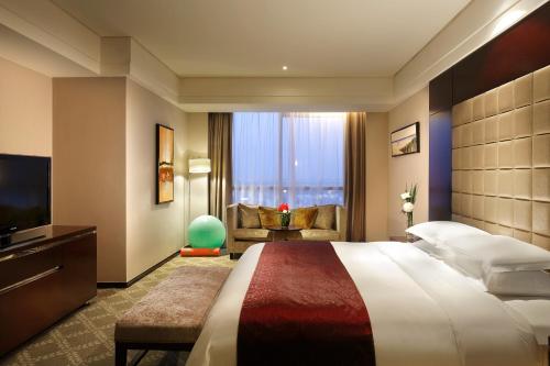 上海浦东绿地铂骊酒店- 浦东国际机场的酒店客房设有一张大床和一台电视。