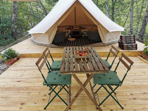 ŠmarjeECO Camp Supot的木甲板上的桌椅和帐篷
