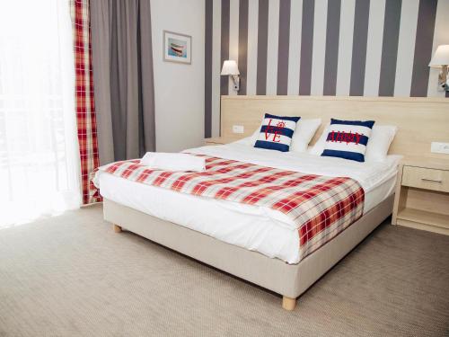 库瑞尼卡慕斯卡Porto Marina的一间卧室配有一张带红白毯子的床