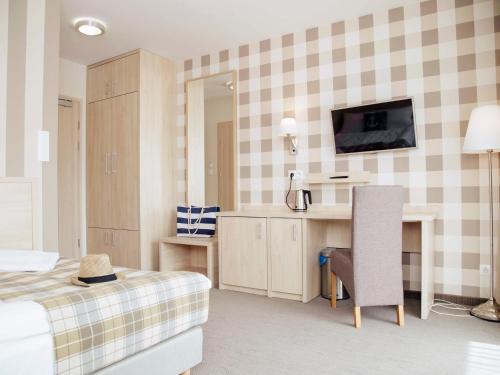 库瑞尼卡慕斯卡Porto Marina的一间卧室配有一张床、一张书桌和一台电视。