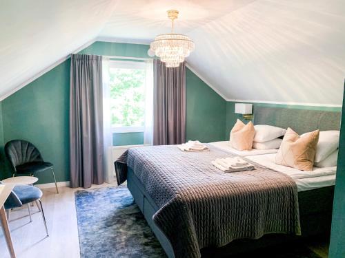 博里霍尔姆多特宁维多利亚酒店与疗养院的一间卧室配有一张带吊灯的大床