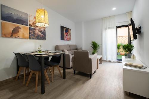 萨拉曼卡Luxor Torre del Clavero Apartments的用餐室以及带桌椅的起居室。