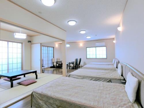 宫崎浴拉宽宫崎酒店的一间设有三张床的房间,内设一张桌子