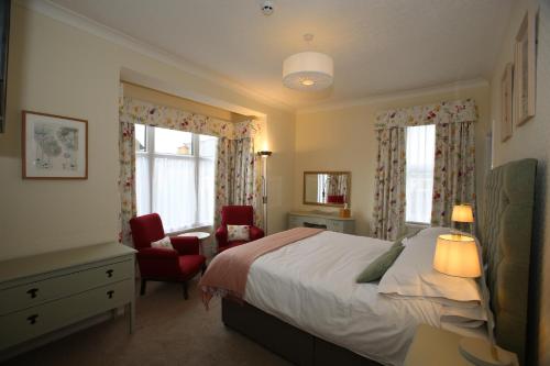 斯卡伯勒科迪莉亚酒店的一间卧室配有一张床和一把椅子,还有两个窗户