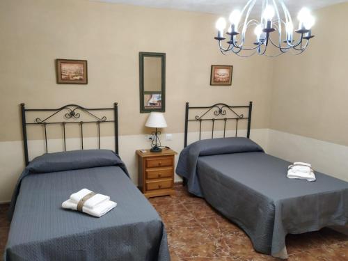 卡索拉CASA LOS ANGULOS的一间卧室配有两张床和吊灯。