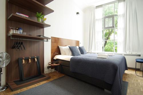 阿姆斯特丹Stuart Luxury Rooms的一间卧室设有一张床和一个窗口